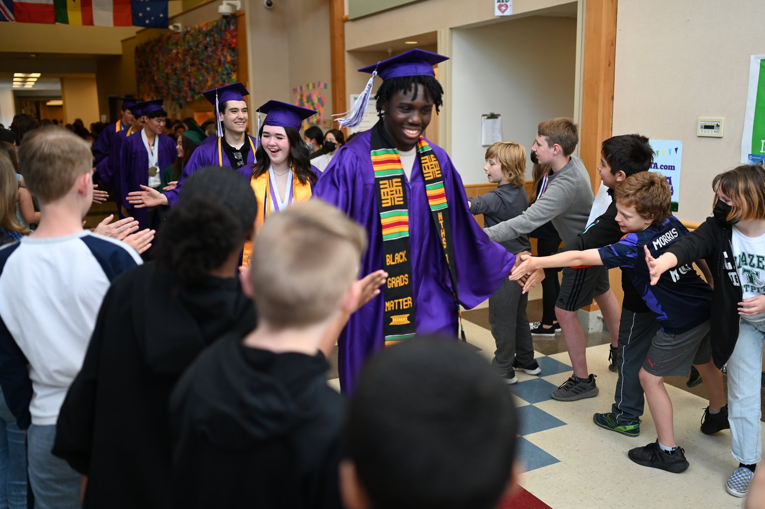 NTHS graduates walking through a corridor of congratulating underclassmen.